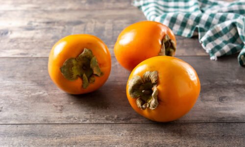 Fresh persimmon fruit on wooden table